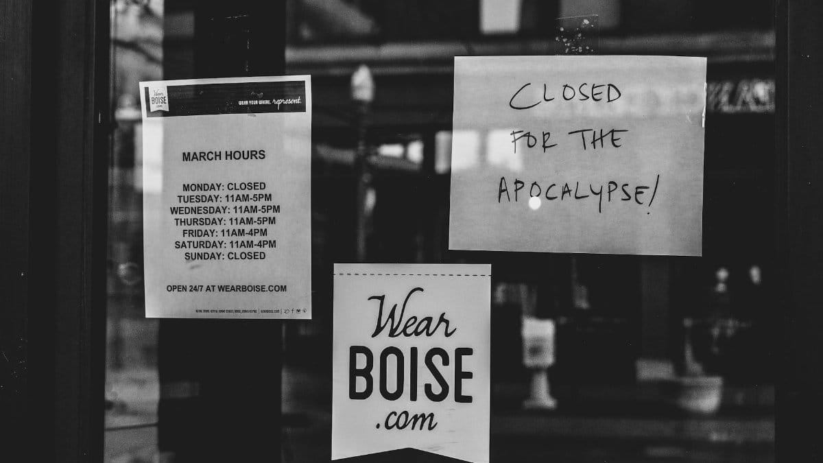 Black and white image of a closed storefront in Boise with humorous signs about closure.