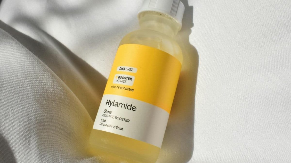A close-up image of the Hylamide Glow Radiance Booster skincare product on white fabric.