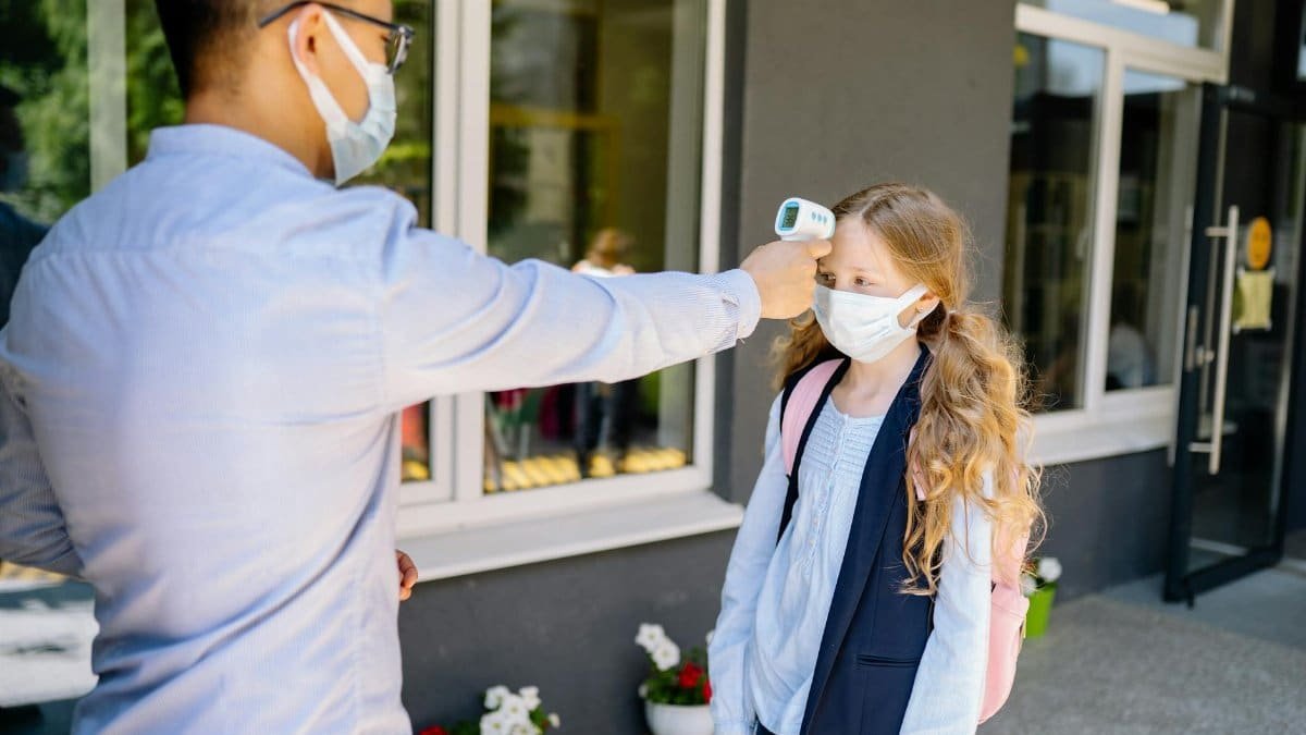 A schoolgirl undergoes a temperature screening as part of COVID-19 safety measures.