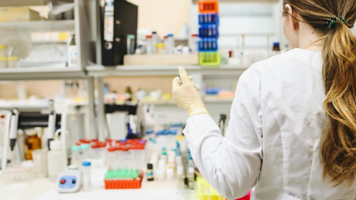 A woman in a laboratory setting conducting scientific research with test tubes.