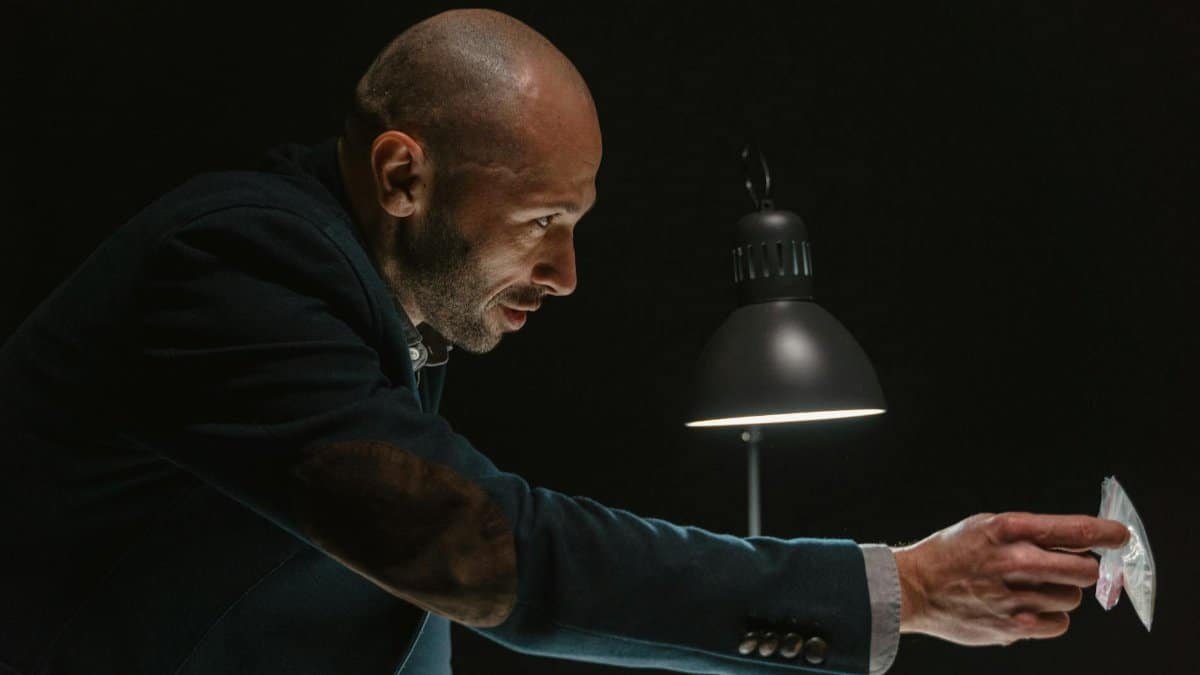 A detective presenting evidence during an intense interrogation scene.