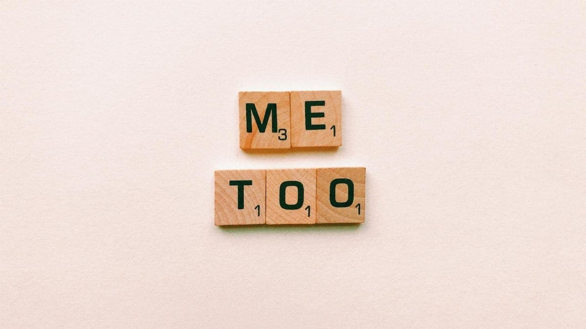 Wooden tiles spelling 'Me Too' on a plain background, symbolizing empowerment.