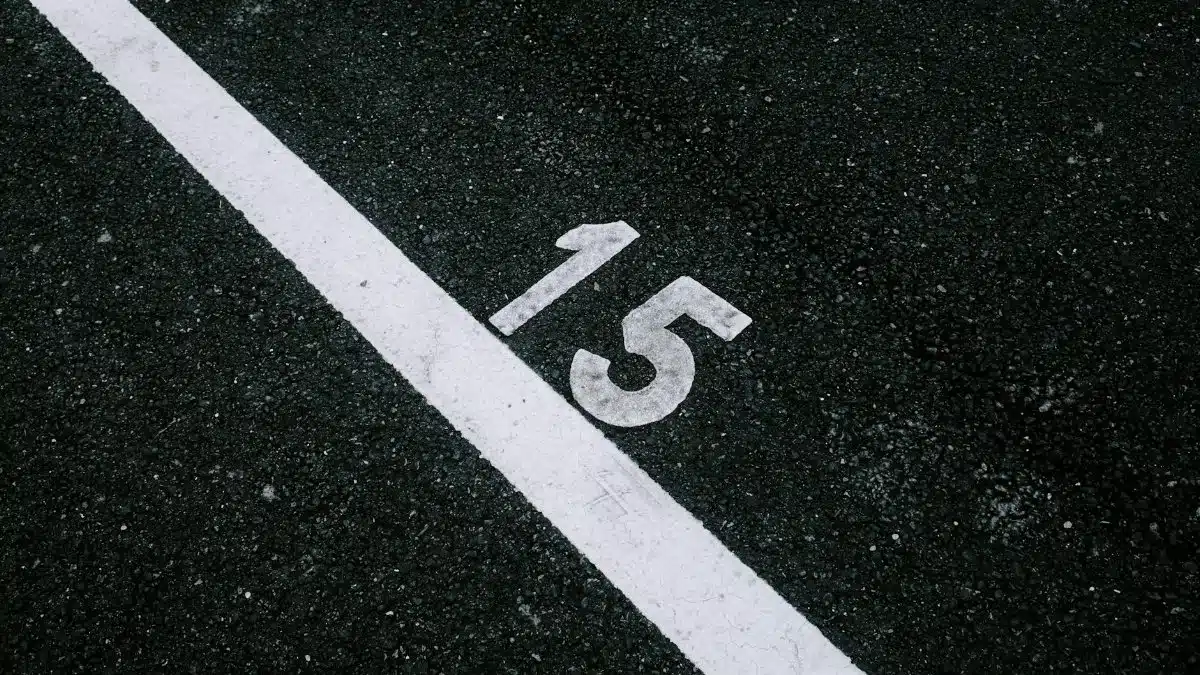Asphalt surface with the number 15 beside a white line, ideal for transportation themes.