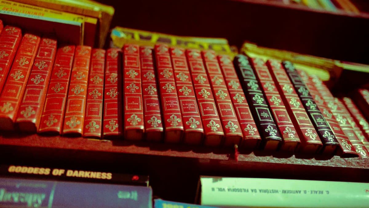 A close-up of a collection of vintage red books on a shelf, offering a classic literary vibe.