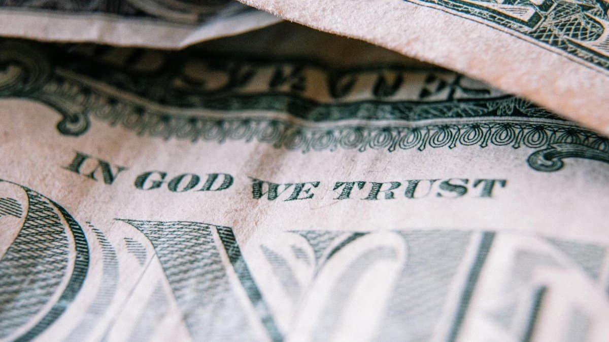 Detailed close-up of a US dollar bill showing 'In God We Trust' motto.