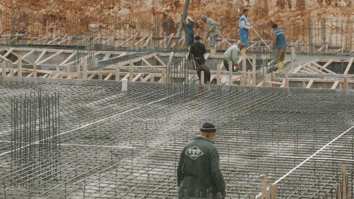 Workers building a foundation with rebar at a construction site.