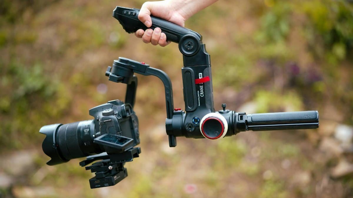 Close-up of a camera on a gimbal stabilizer held outdoors, showcasing photography equipment.