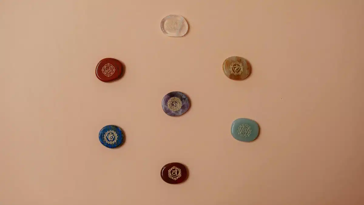Flat lay of colorful chakra stones arranged on a brown surface, perfect for meditation.