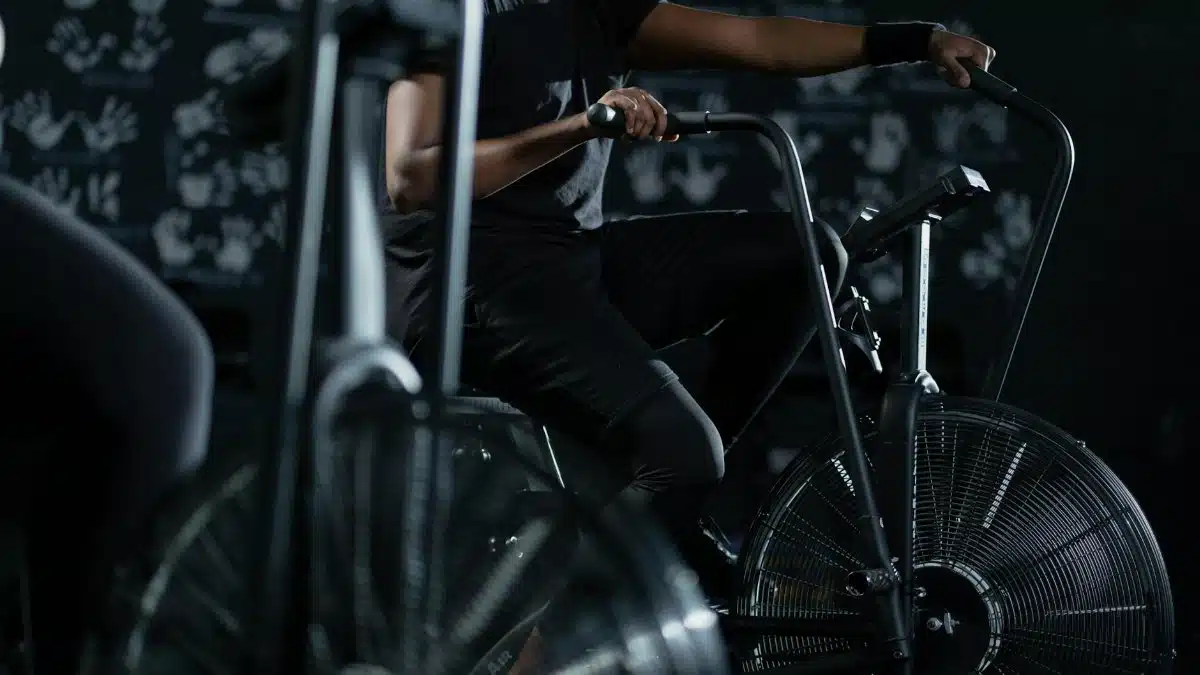 A person engaged in an intense indoor cycling workout on a stationary exercise bike, promoting fitness and healthy living.