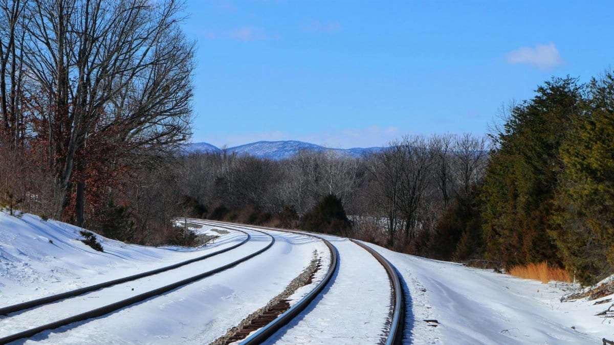 Snow-covered railway tracks curving through a winter landscape in Front Royal, Virginia.