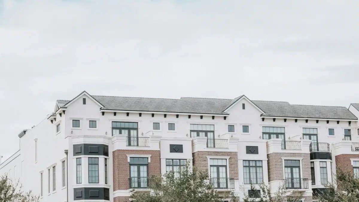 A stylish, multi-story luxury apartment building with a contemporary facade against a clear sky.