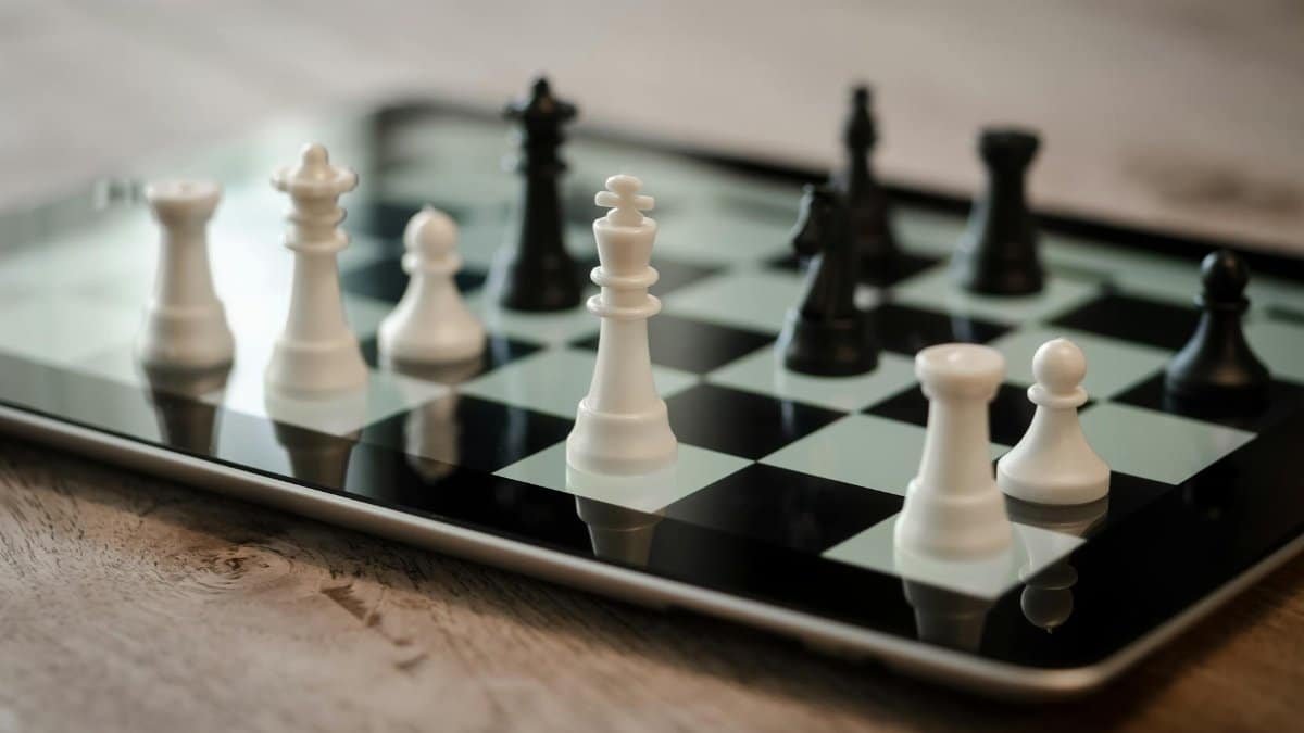 Close-up of chess game on a tablet featuring white and black pieces, emphasizing strategy and technology.