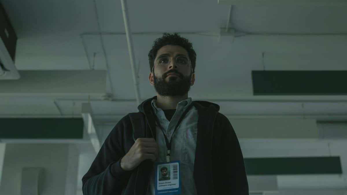 Portrait of a bearded man with ID indoors, signifying technology role.