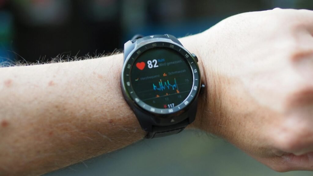 Close-up of a smartwatch showing heart rate and data on a person's wrist outdoors.