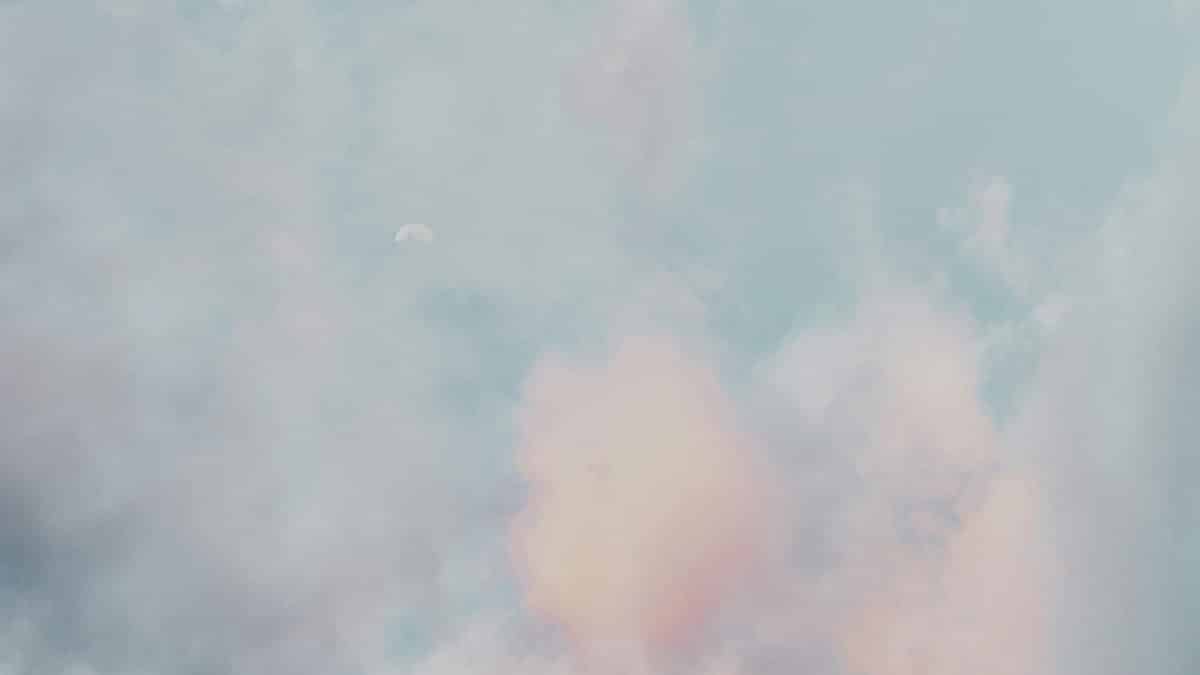 A serene scene of pastel clouds and a subtle moon in a calming sky, perfect for a peaceful backdrop.