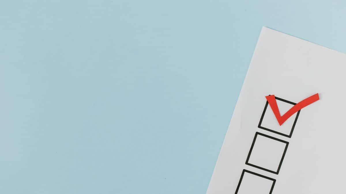 A checklist with a red checkmark symbolizing a completed task on a pastel blue background.