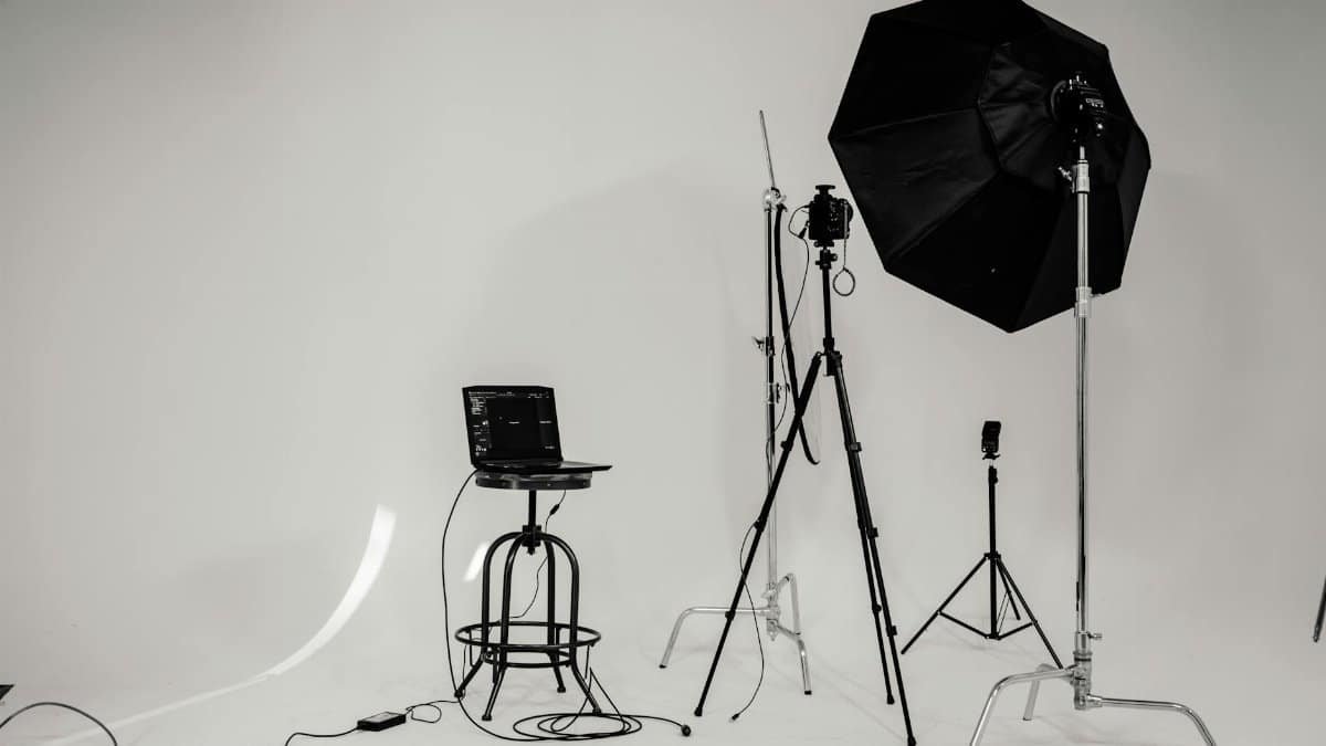 A black and white photo of a well-equipped photography studio with lighting equipment and tripods.