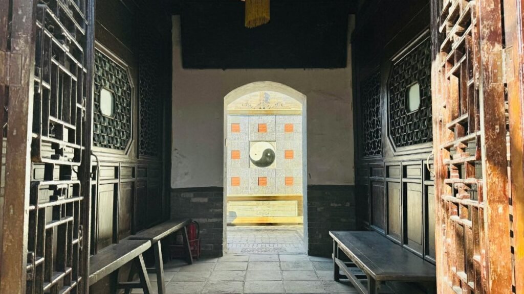 Entrance view of a traditional Chinese courtyard featuring a prominent Yin Yang symbol.