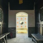 Entrance view of a traditional Chinese courtyard featuring a prominent Yin Yang symbol.