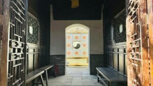 Entrance view of a traditional Chinese courtyard featuring a prominent Yin Yang symbol.