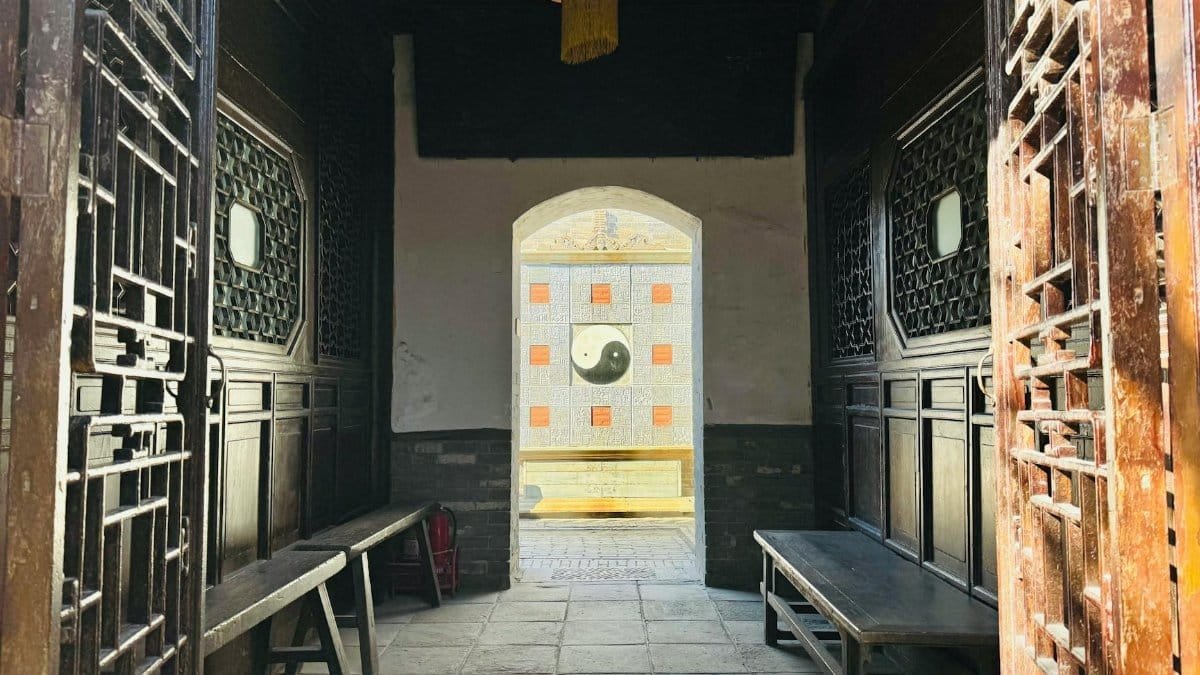 Entrance view of a traditional Chinese courtyard featuring a prominent Yin Yang symbol.