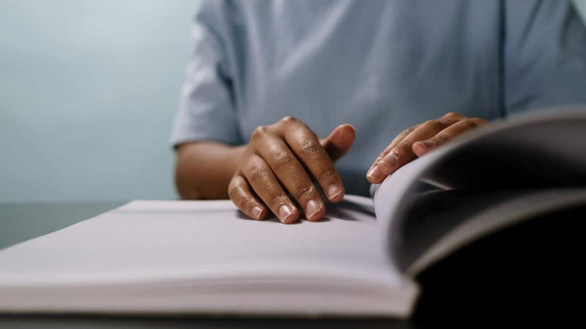 A person attentively flipping through pages of a book, creating a focused study ambiance.