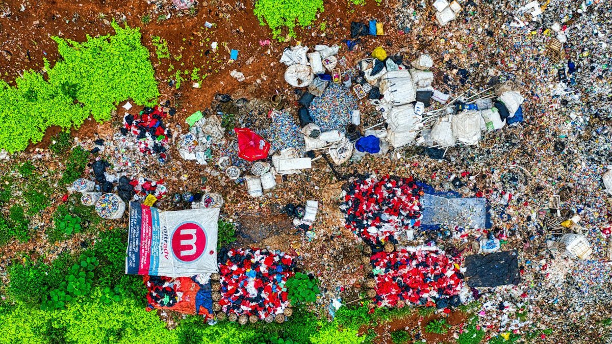An aerial shot showing piles of waste in a dumpsite surrounded by greenery in Banten, Indonesia.