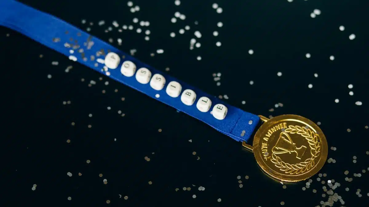 Close-up of a gold medal on a blue ribbon with 'possible' beading, symbolizing achievement.