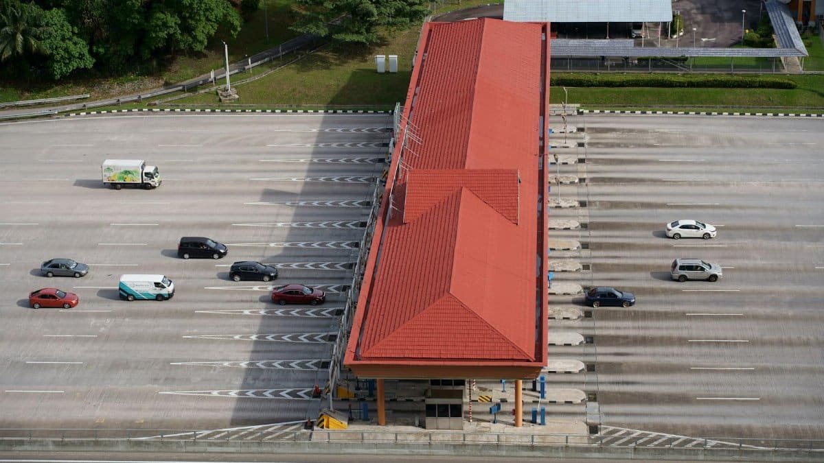 High angle aerial shot of a toll plaza with cars and trucks on an expansive highway.