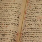 Close-up of an ancient manuscript with handwritten texts and ink inscriptions.