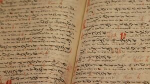 Close-up of an ancient manuscript with handwritten texts and ink inscriptions.