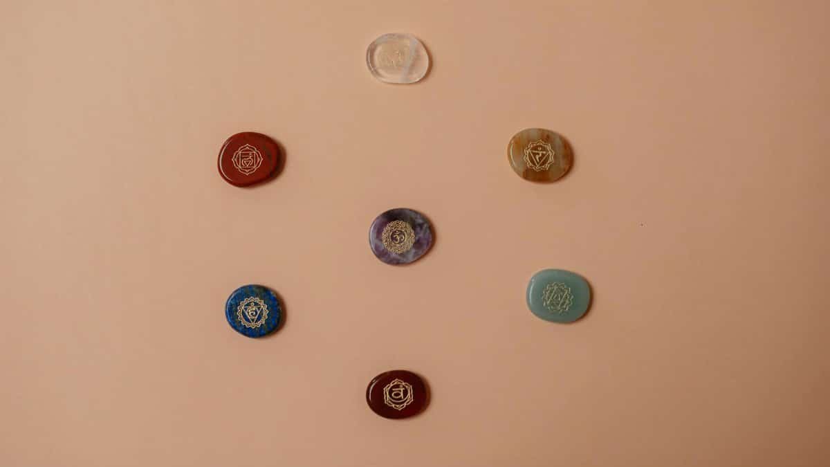 Flat lay of colorful chakra stones arranged on a brown surface, perfect for meditation.