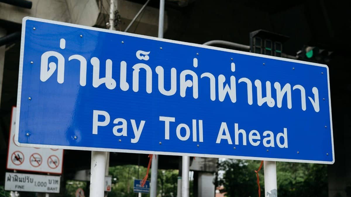 Blue sign indicating a toll road ahead, located in Bangkok, Thailand.