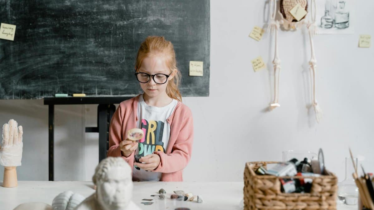 Girl experimenting with rocks in a classroom. Engaged in scientific learning and exploration.