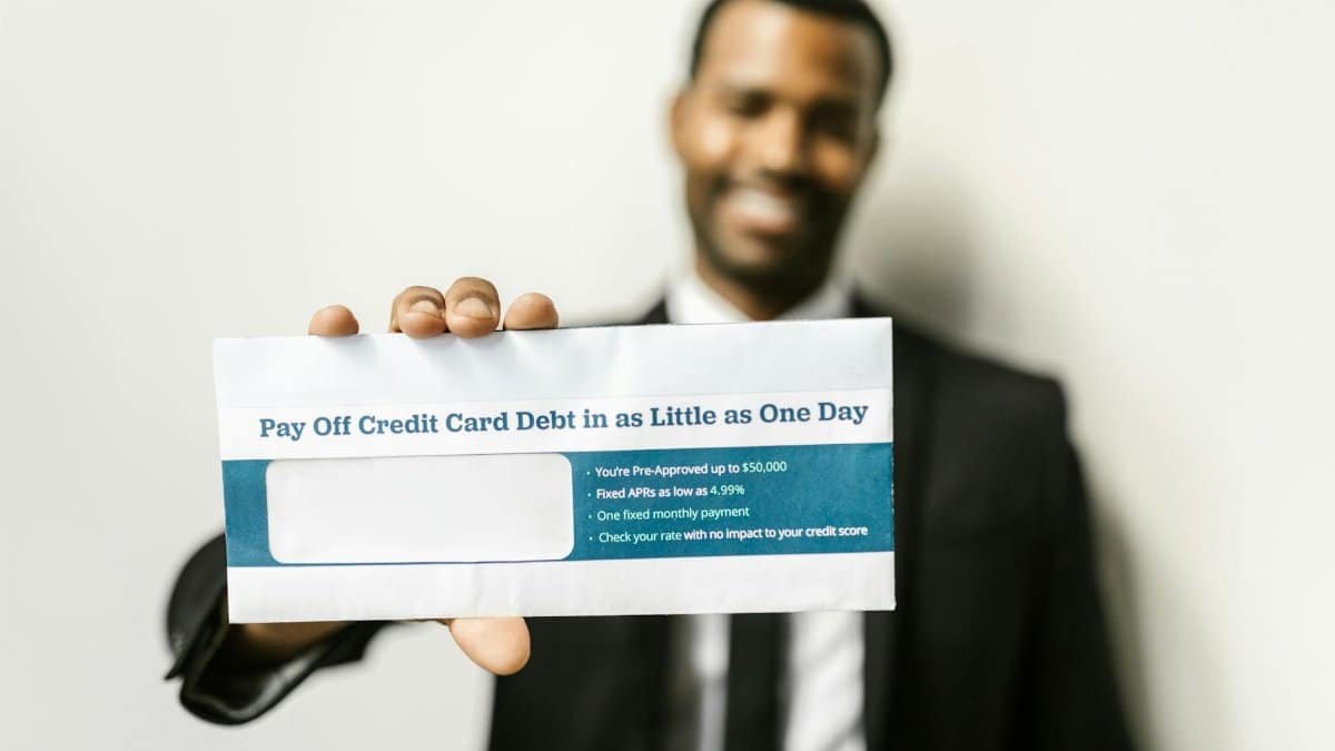 African American man holding envelope emphasizing credit card debt relief options.