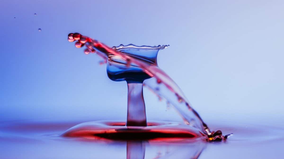 Close-up of a vibrant water splash captured mid-action, showcasing fluid dynamics and color contrasts.
