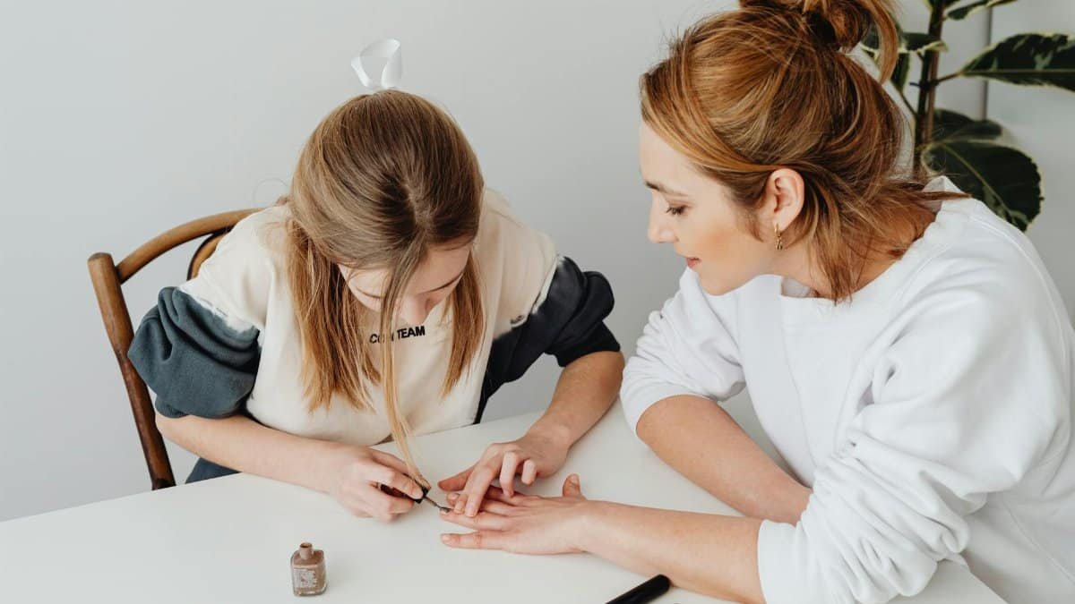 A mother and daughter bonding over a relaxing nail care session at home.