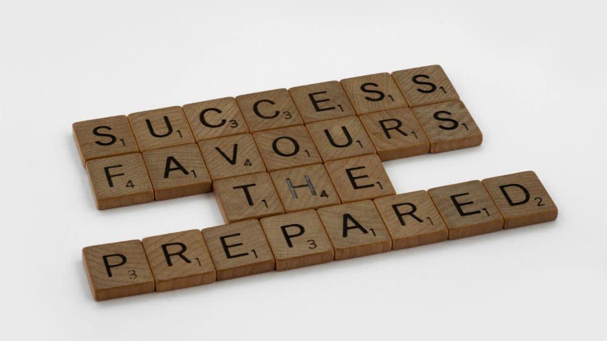 Scrabble tiles on a white surface forming the phrase 'Success Favours the Prepared'.