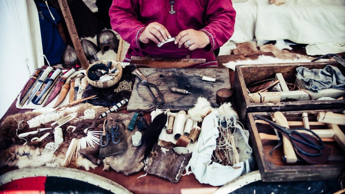 Artisan crafting tools and materials in a traditional workshop setting.