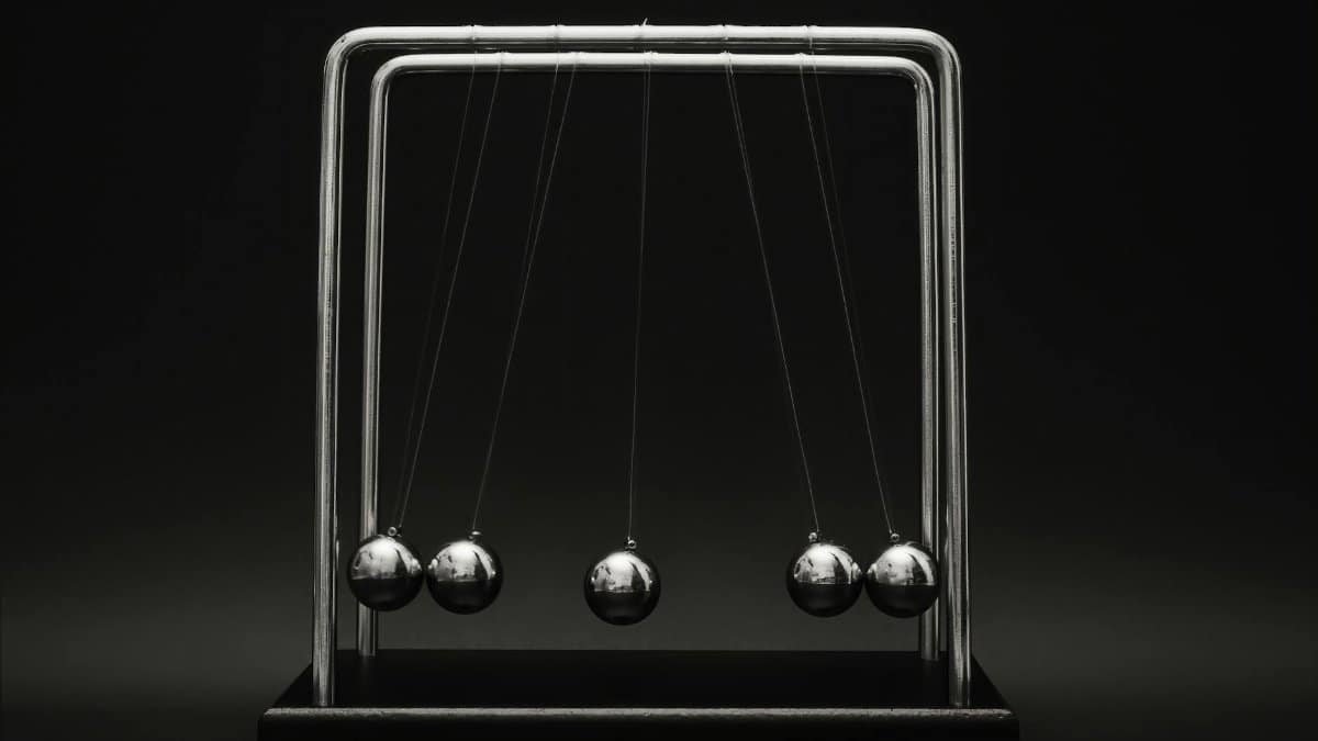 Newton's cradle for physics principles and motion study on a dark background.