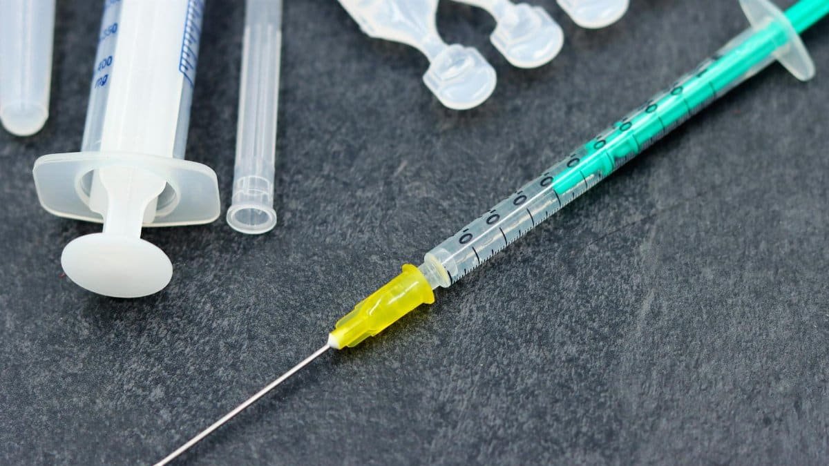 Detailed image of a syringe and medical supplies, ideal for healthcare and vaccination themes.