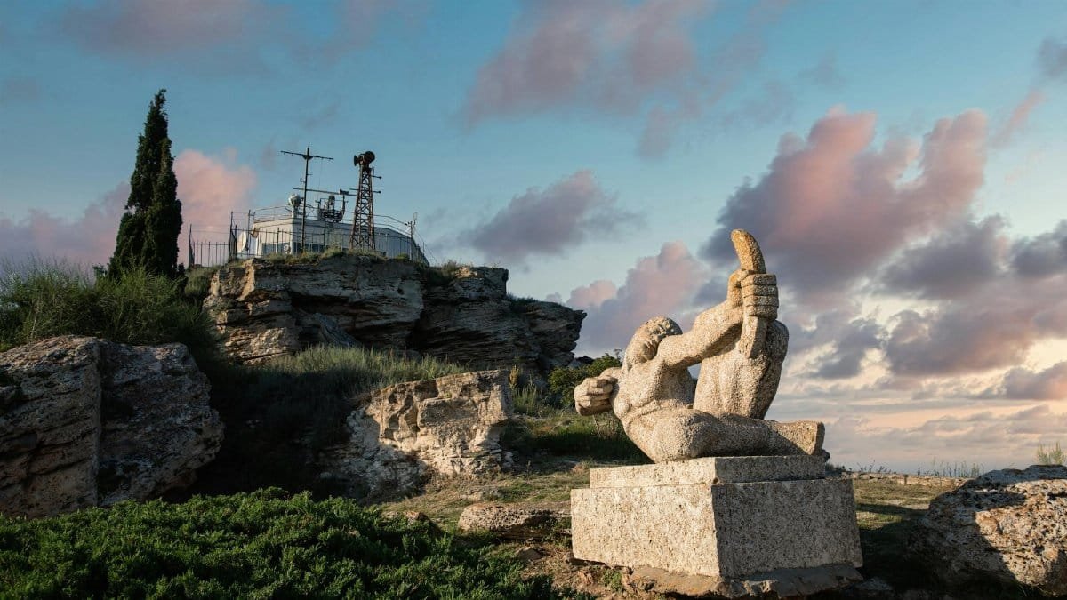 A captivating ancient stone sculpture set against a beautiful hillside landscape, ideal for travel imagery.