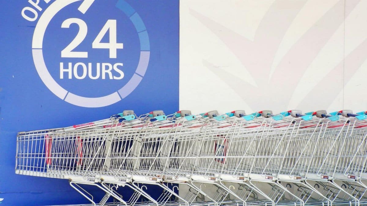Row of shopping trolleys outside a 24-hour supermarket in Singapore, emphasizing convenience and accessibility.