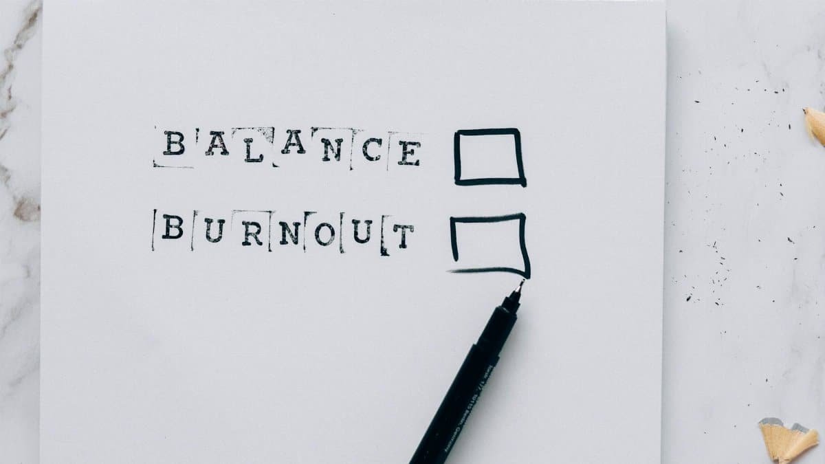 A minimalist image depicting the choice between balance and burnout with checkboxes.