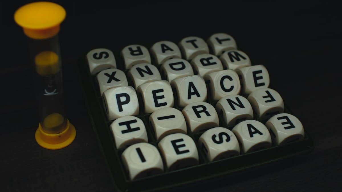 Lettered dice game with visible letters and a small timer on a dark surface.