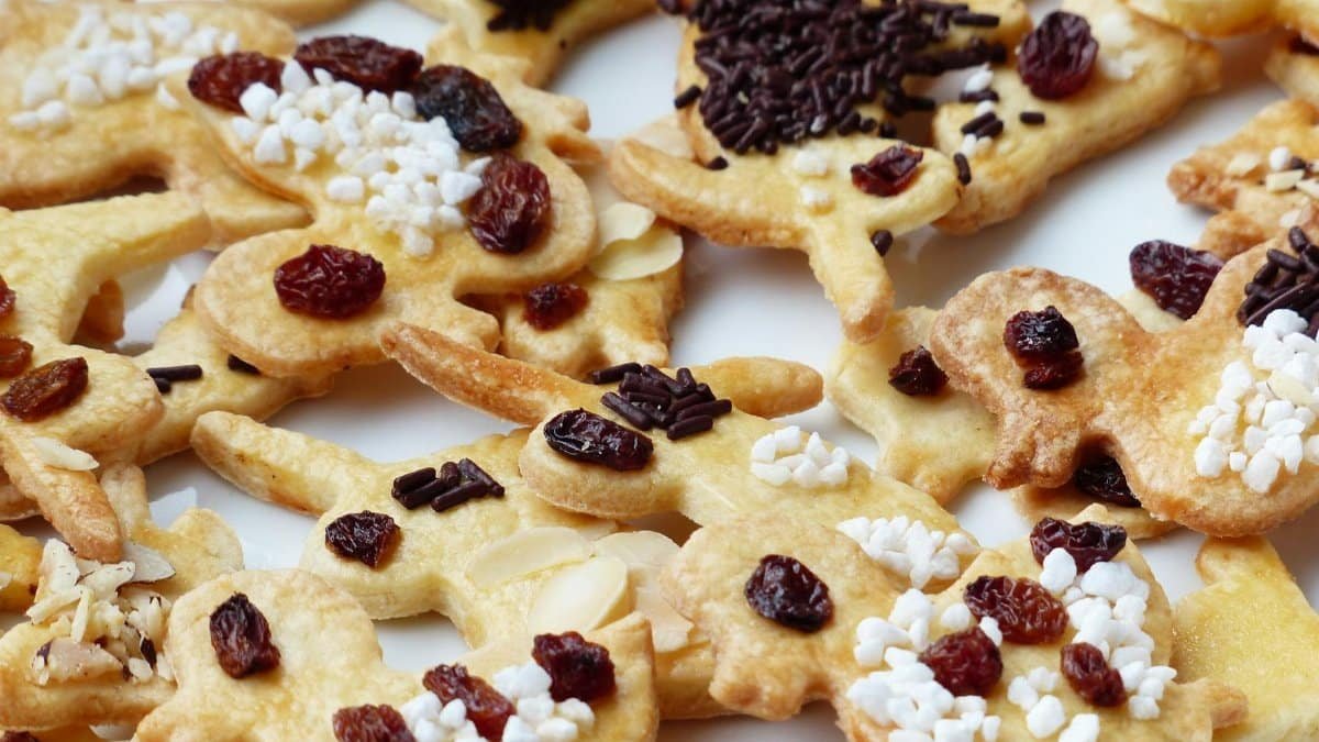 Delicious homemade gingerbread cookies decorated with raisins and sprinkles. Perfect for festive occasions.