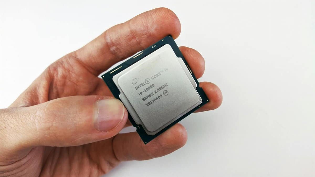 Close-up view of a hand holding an Intel Core i9 processor chip, showcasing technology details.