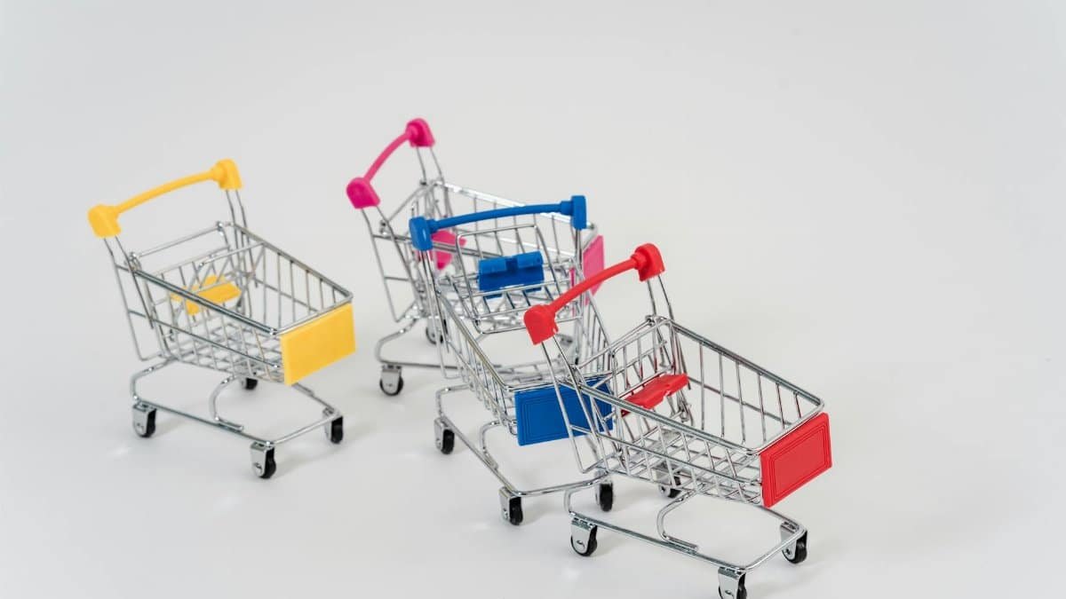 Three mini shopping carts with colorful handles and labels on a white background.