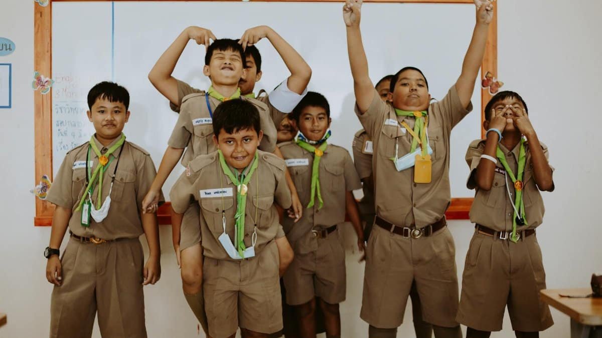 Playful school children in uniforms having fun during a classroom session.