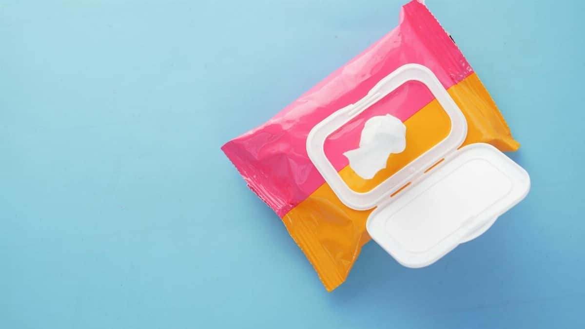 Brightly colored wet wipes package on a blue surface, symbolizing hygiene and cleanliness.
